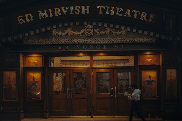 A Woman Walking In Front Of The Ed Mirvish Theatre