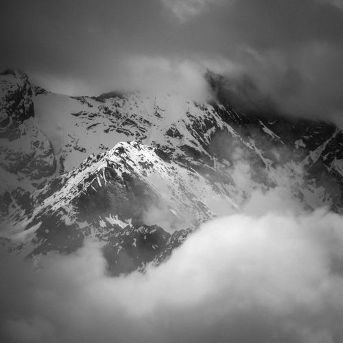 Free A striking monochrome view of the mist-covered Swiss Alps, showcasing rugged, snowy peaks. Stock Photo