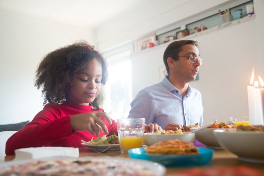A family enjoying dinner together at home with a variety of dishes.
