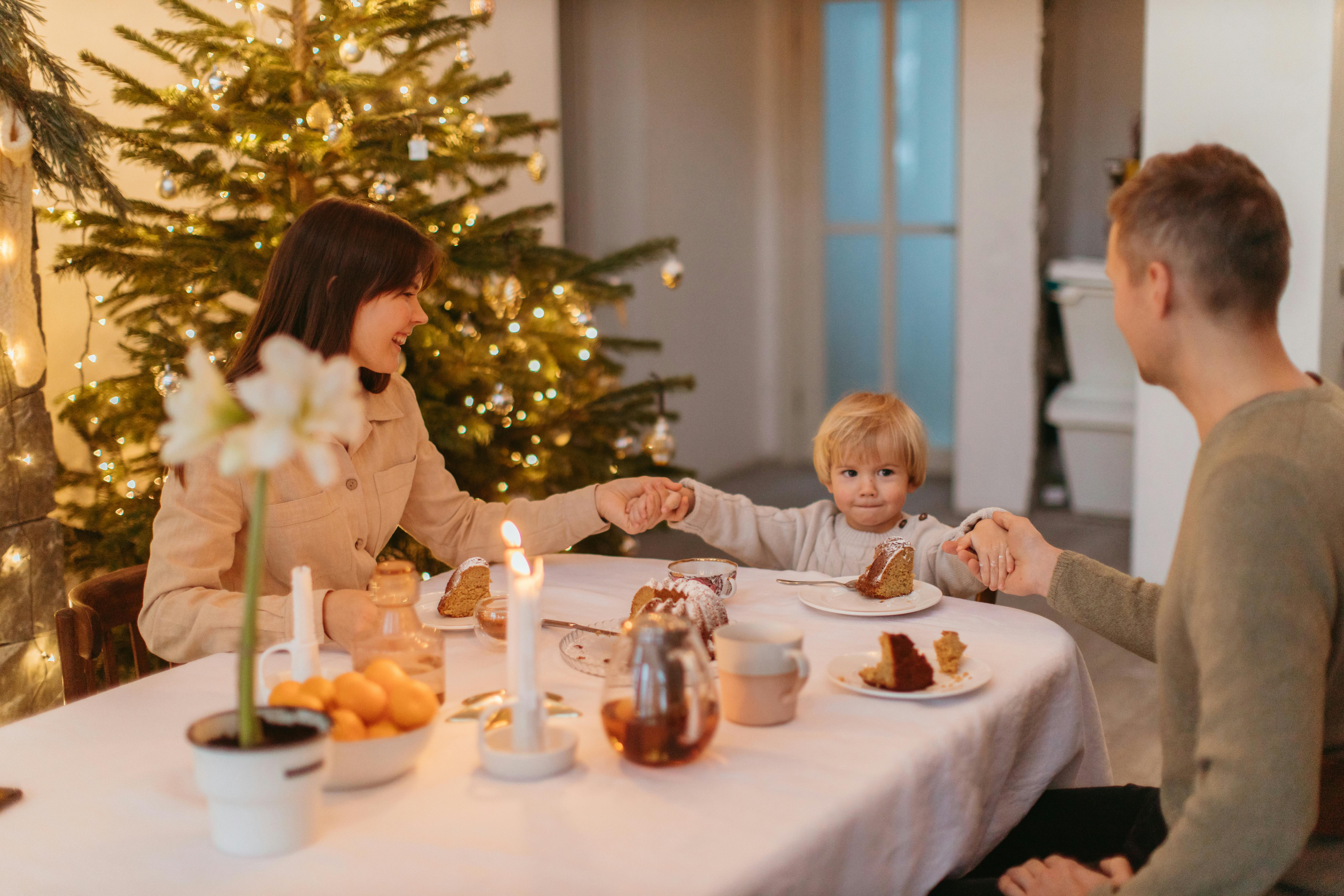 2 children sitting on chair in front of table with candles and candles