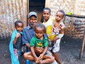 A warm family portrait with a grandfather and children outdoors, showcasing love and togetherness.