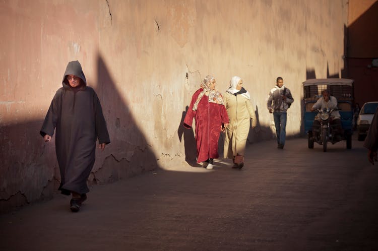 Anonymous Local Ethnic People Walking In Old Town On Sunny Day