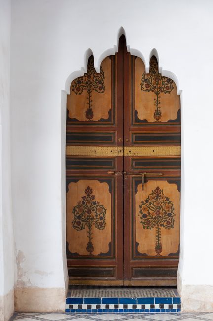 Life tree paintings on wooden door in aged Bahia Palace located in Morocco