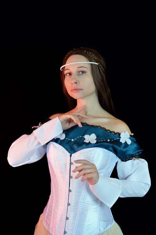 Stylish woman in fancy medieval dress touching neck tenderly