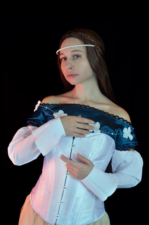 Attractive woman in medieval dress and pearl diadem in studio