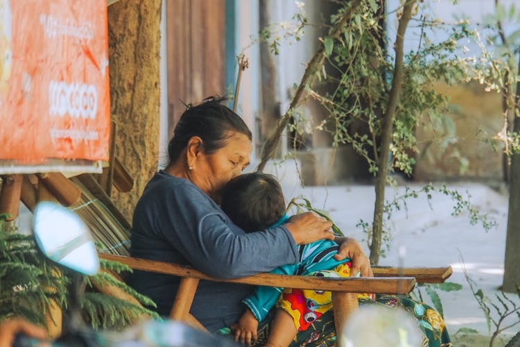 A Woman Holding Her Sleeping Grandchild