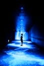 Woman Standing in Blue Light in Corridor