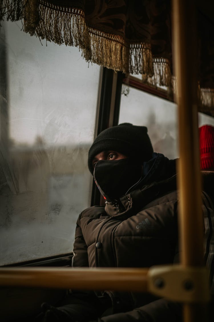 A Man In Black Jacket Sitting Inside The Bus