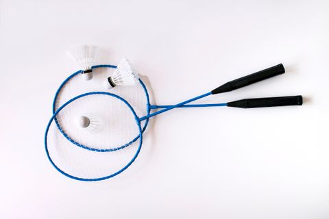 Two blue badminton racquets with shuttlecocks on white