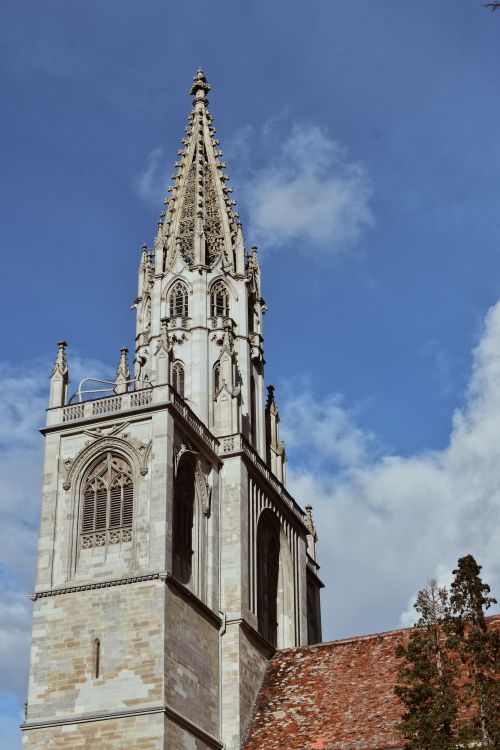 Free Elevated view of a historic Gothic church tower with intricate details against a clear blue sky. Stock Photo
