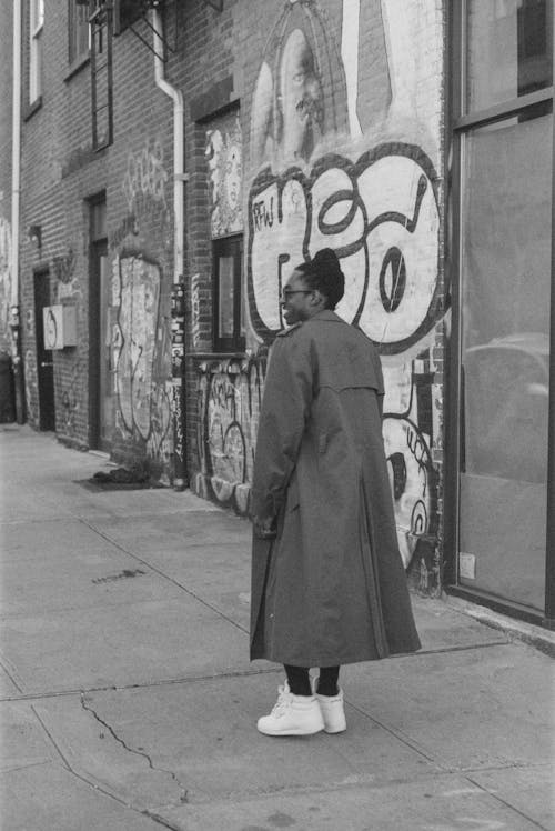 Person Wearing a Coat Standing on Sidewalk