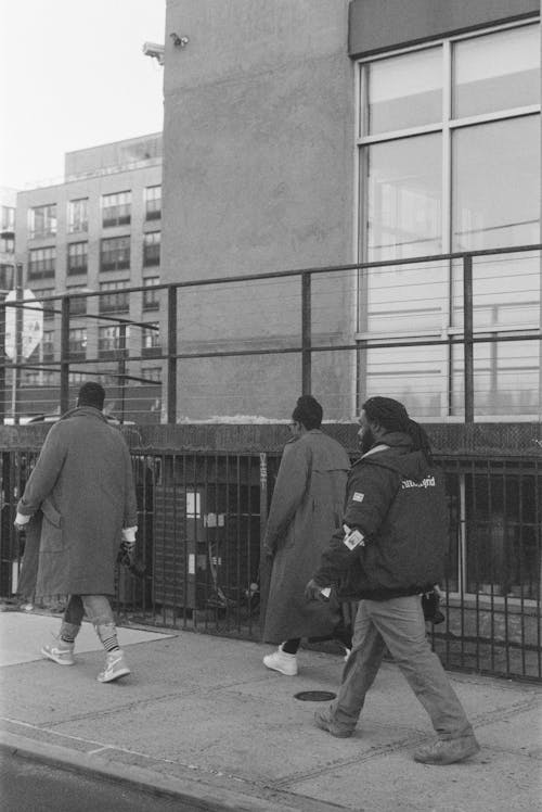 Monochrome Shot of People Walking on Sidewalk