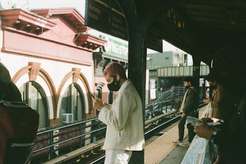 бесплатная Человек в белом халате стоит на вокзале Стоковое фото