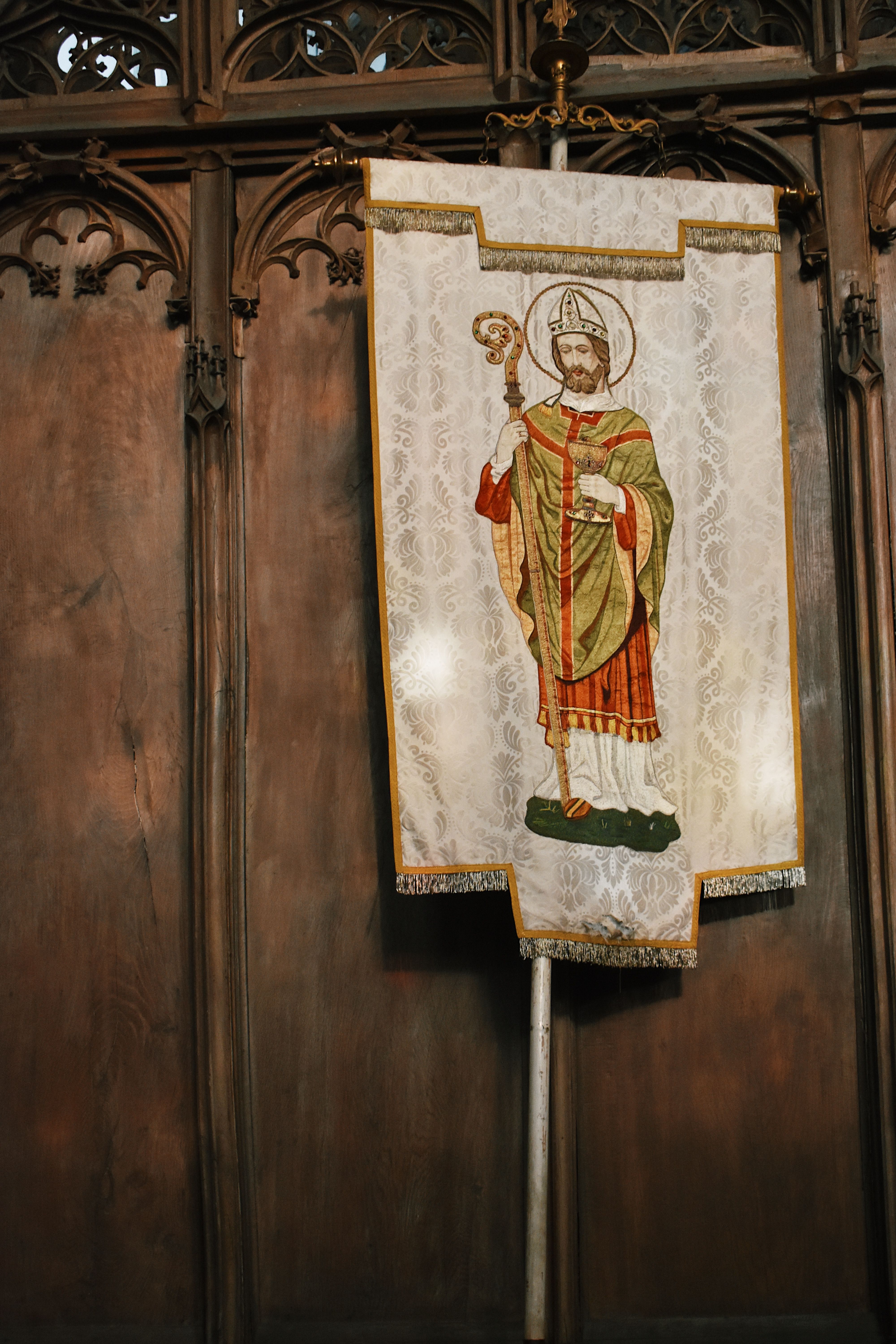 Decorative embroidered banner with religious icon in a church setting.