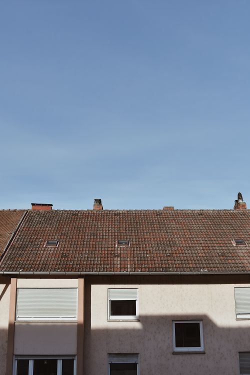 Free A minimalist view of a residential building roof against a clear blue sky, perfect for architectural themes. Stock Photo