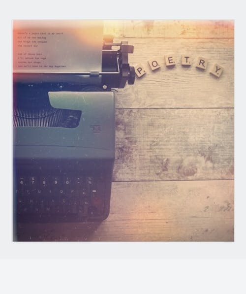 Black Typewriter Beside Scrabble Tiles on Brown Wooden Table
