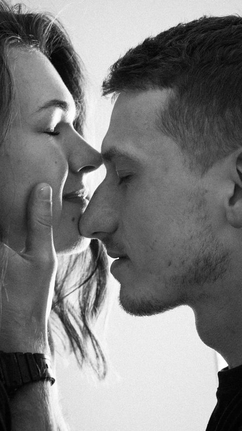 Free Black and white portrait of intimate couple with closed eyes sharing a moment. Stock Photo