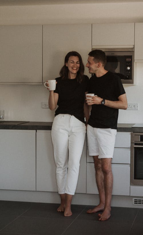Couple Standing in the Kitchen Drinking Coffee