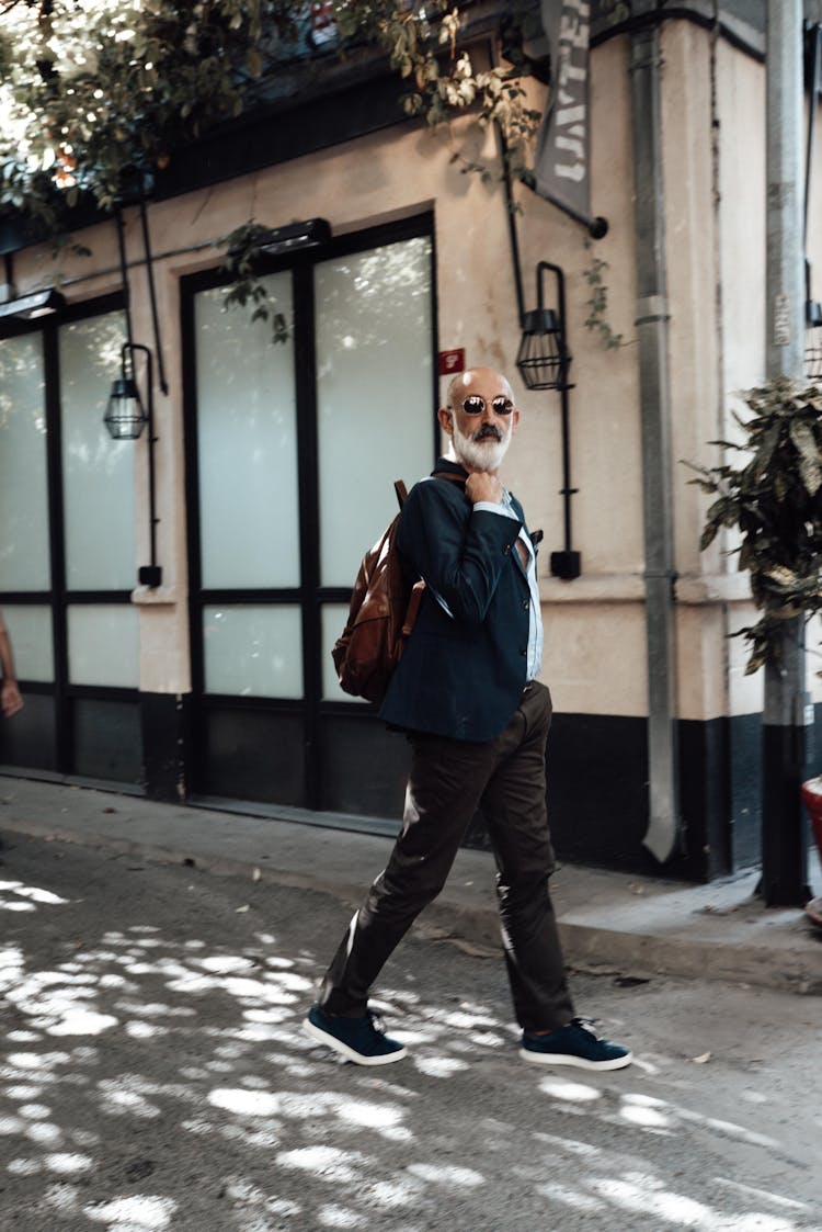 Stylish Senior Ethnic Man Walking In Old Town On Sunny Day