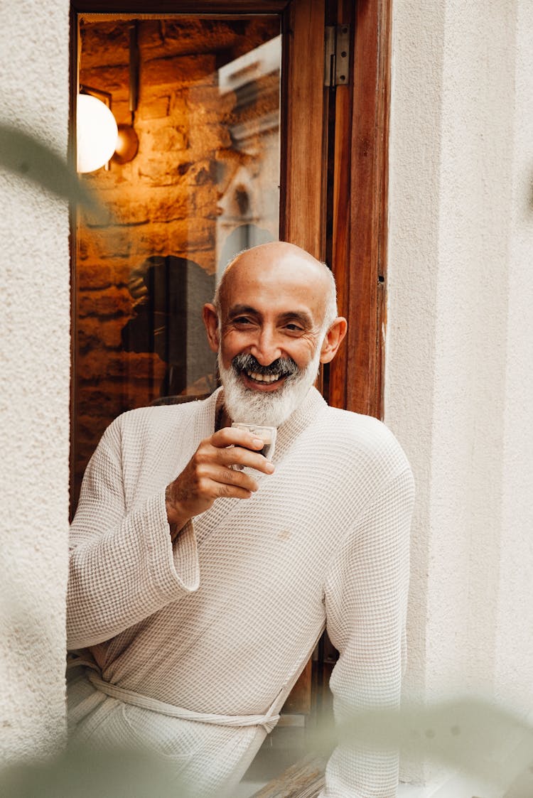 Happy Elderly Ethic Man Drinking Coffee On Balcony