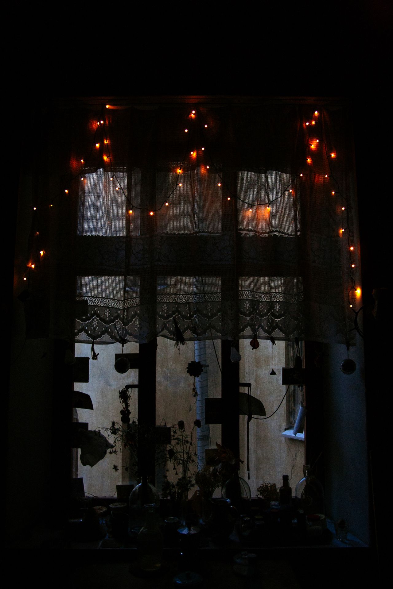 String lights glowing on a window at night