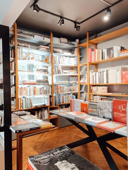 Free Collection of various books placed on wooden shelves in modern store with parquet floor and minimalist interior Stock Photo
