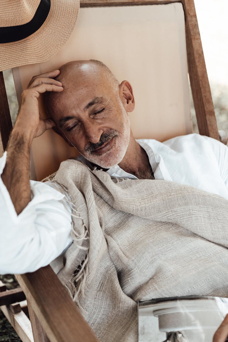 Ethnic Man Sleeping On Chair In Daytime