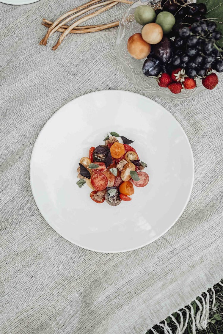 Plate With Salad Near Fruits And Berries On Picnic Blanket