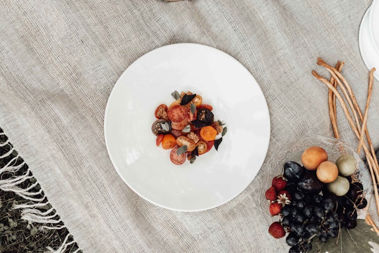 Salad On Plate Near Fruits With Berries On Picnic Cloth