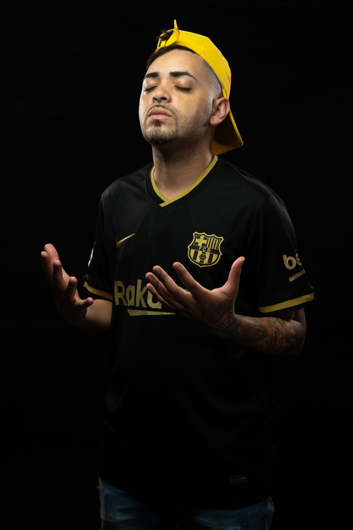 Free A man poses with closed eyes in a Barcelona soccer jersey against a dark background. Stock Photo