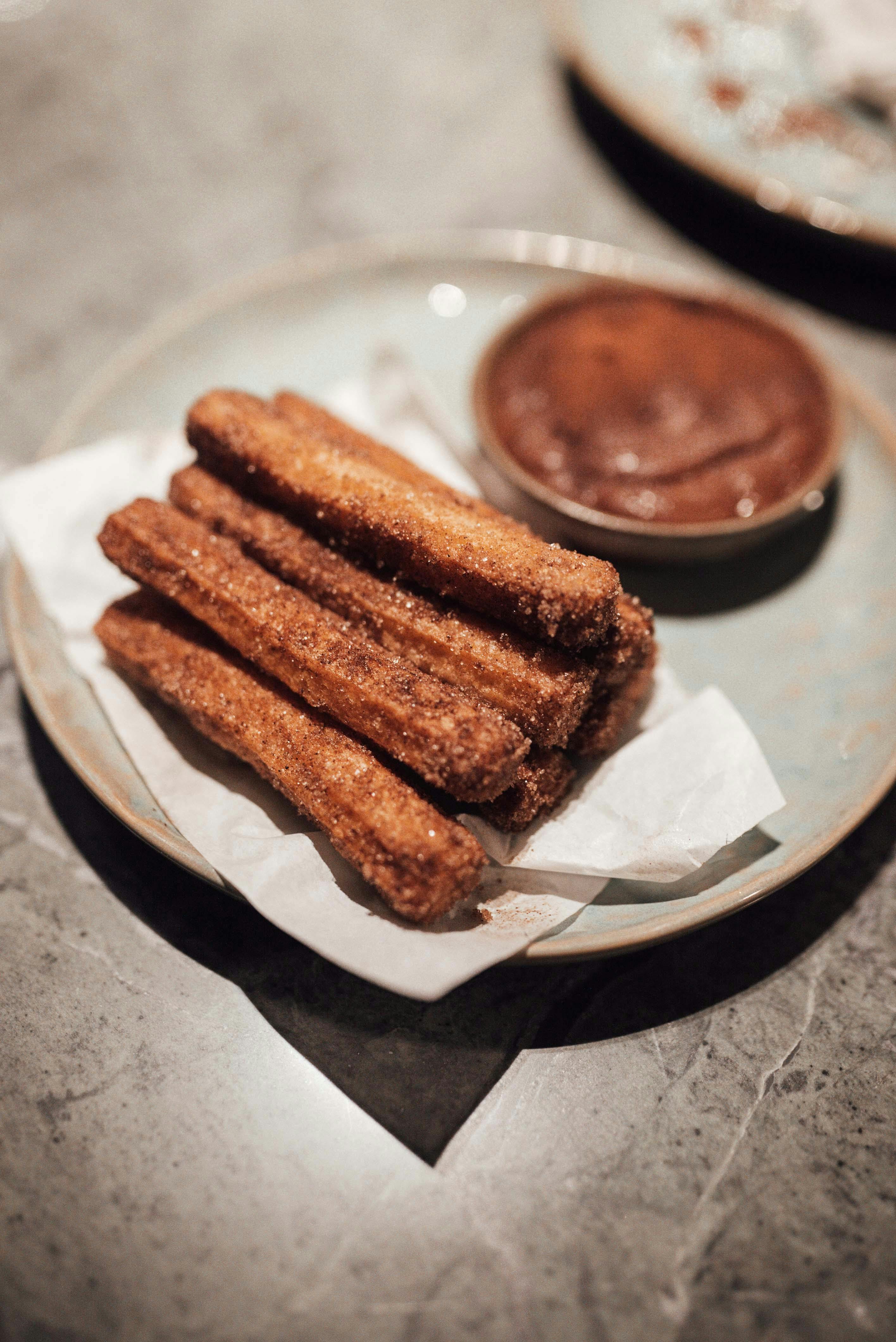 Delicious churros with chocolate sauce served on plate in cafe · Free ...