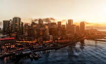 日落时分，旧金山明亮的天际线在海湾水面上映出戏剧性的鸟瞰景象