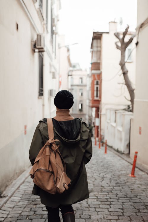 Anonymous tourist strolling in old city district on cloudy day