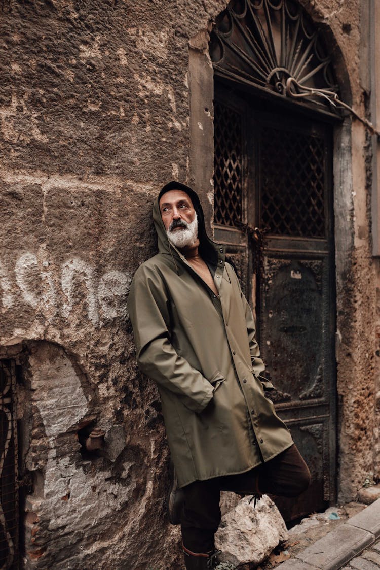 Bearded Hispanic Man Leaning On Rough Old House Wall