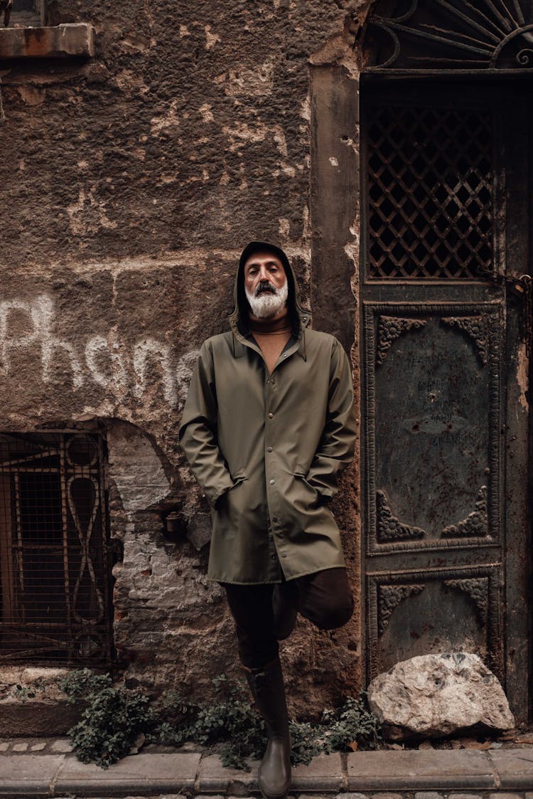 Masculine Hispanic Man Leaning On Aged Construction In City