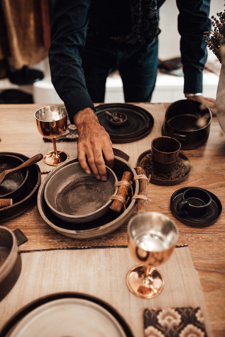 Crop Ethnic Man At Table With Old Dishware