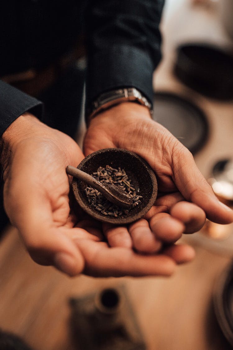 Crop Man Showing Cumin Seeds In Small Bowl