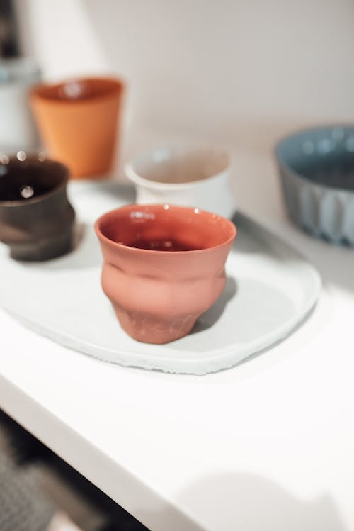 Ceramic cups placed on white shelf