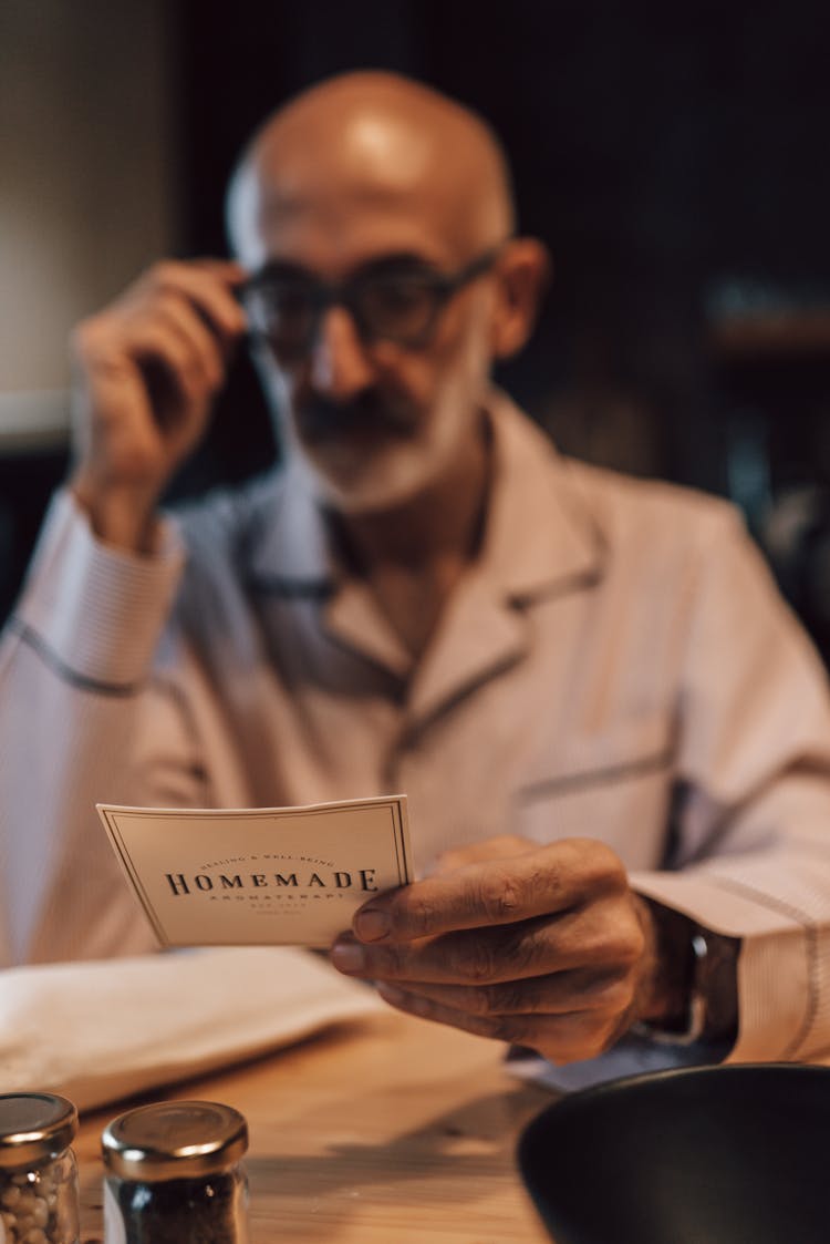 Ethnic Man Reading Menu In Restaurant