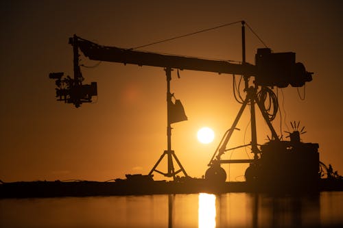Free Modern equipment for filming process in pond against bright sun shining on sunset sky Stock Photo