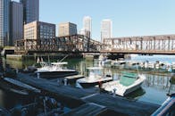 在阳光明媚的日子里，可以欣赏波士顿海滨的风景，那里有船只、建筑物和桥梁