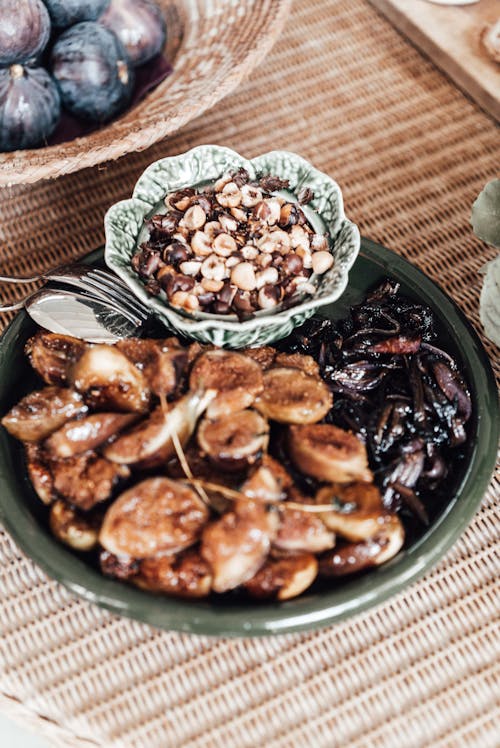 Free From above of tasty dish with figs and prunes served on table near bowl with meal topped with huts on table Stock Photo