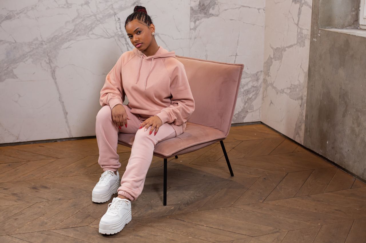 Woman in a blush pink matching hoodie and jogger tracksuit set with chunky white platform sneakers