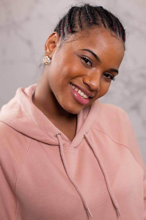Free Positive black woman in pink hoodie smiling Stock Photo