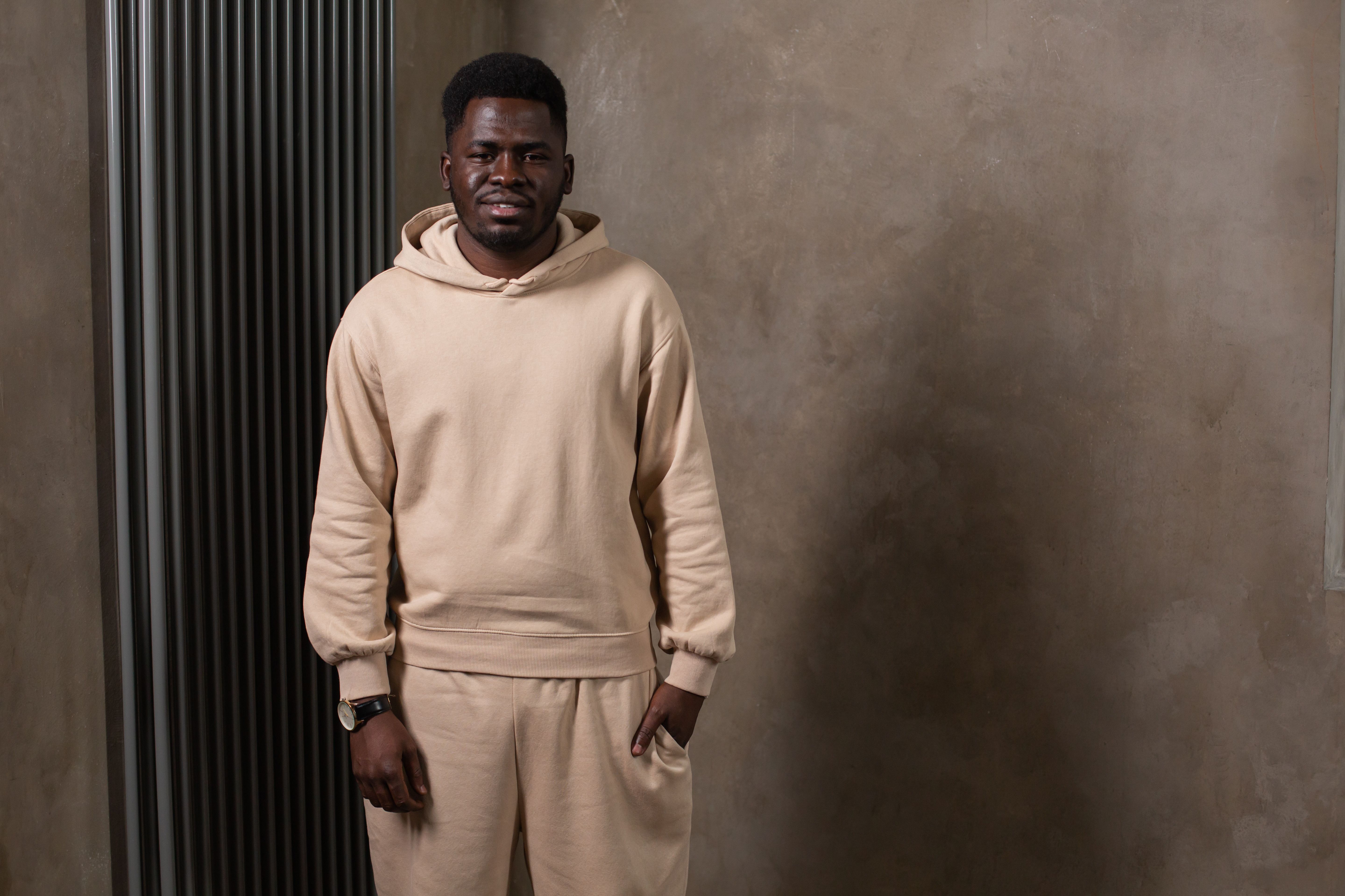 Homme en hoodie beige et jogging coordonné streetwear look total monochrome