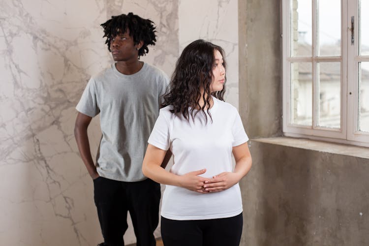 Diverse Friends Near Window Of Gray Walls With Patterns