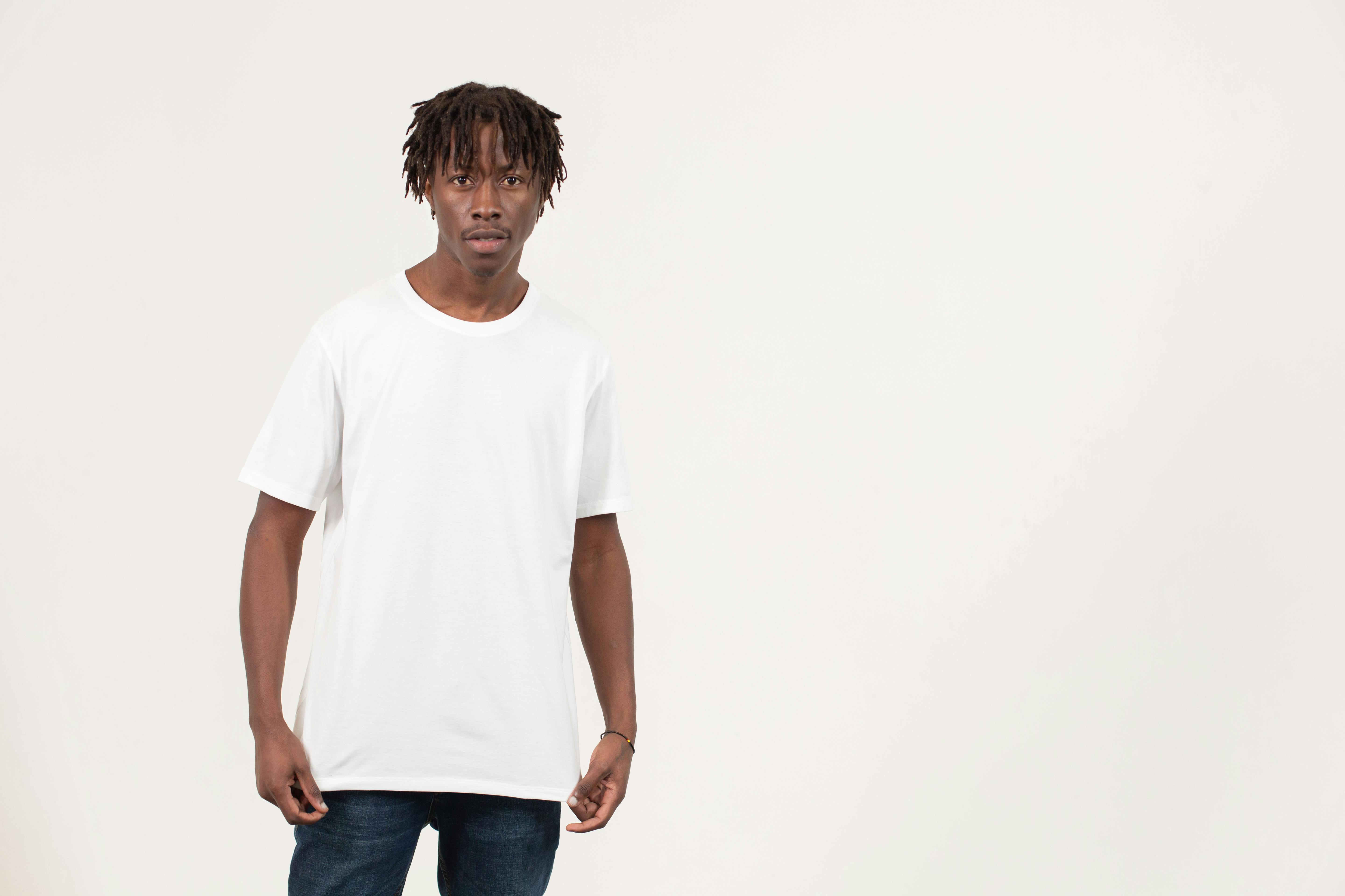 Trendy young black man in casual outfit standing in white studio · Free ...