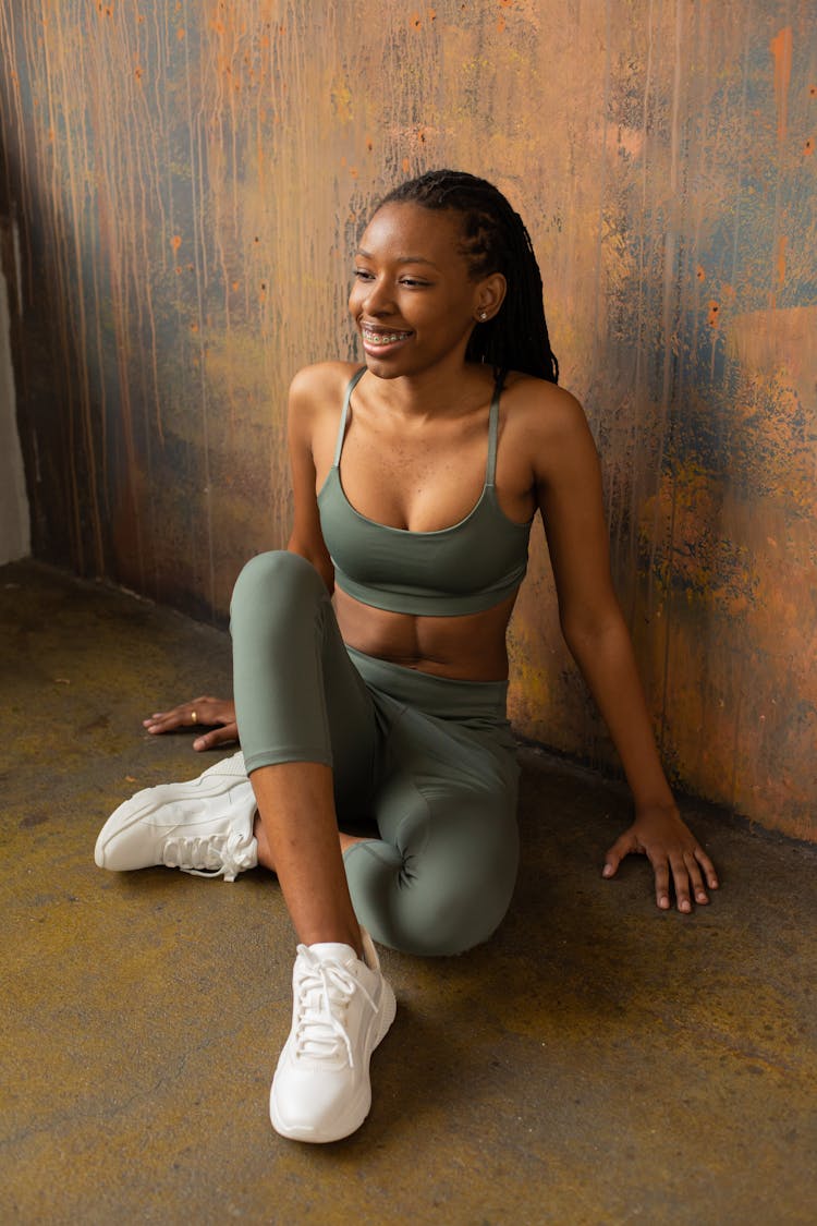 Happy Young African American Sportswoman Resting On Floor And Smiling After Training