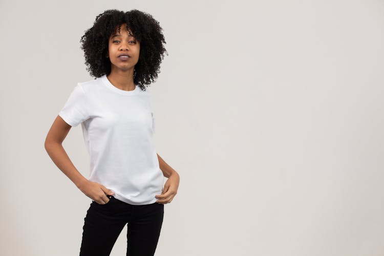 Stylish Young Ethnic Woman Looking At Camera Against White Background