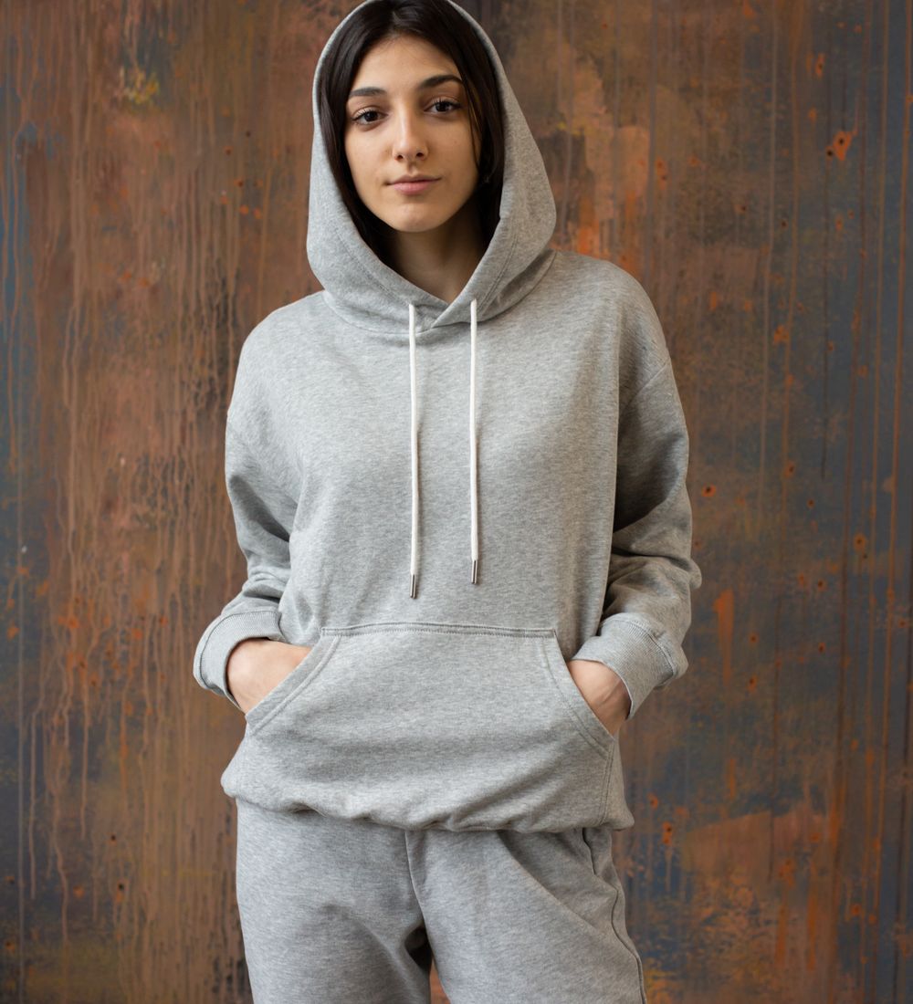Model in a plain grey hoodie, hands in the pocket